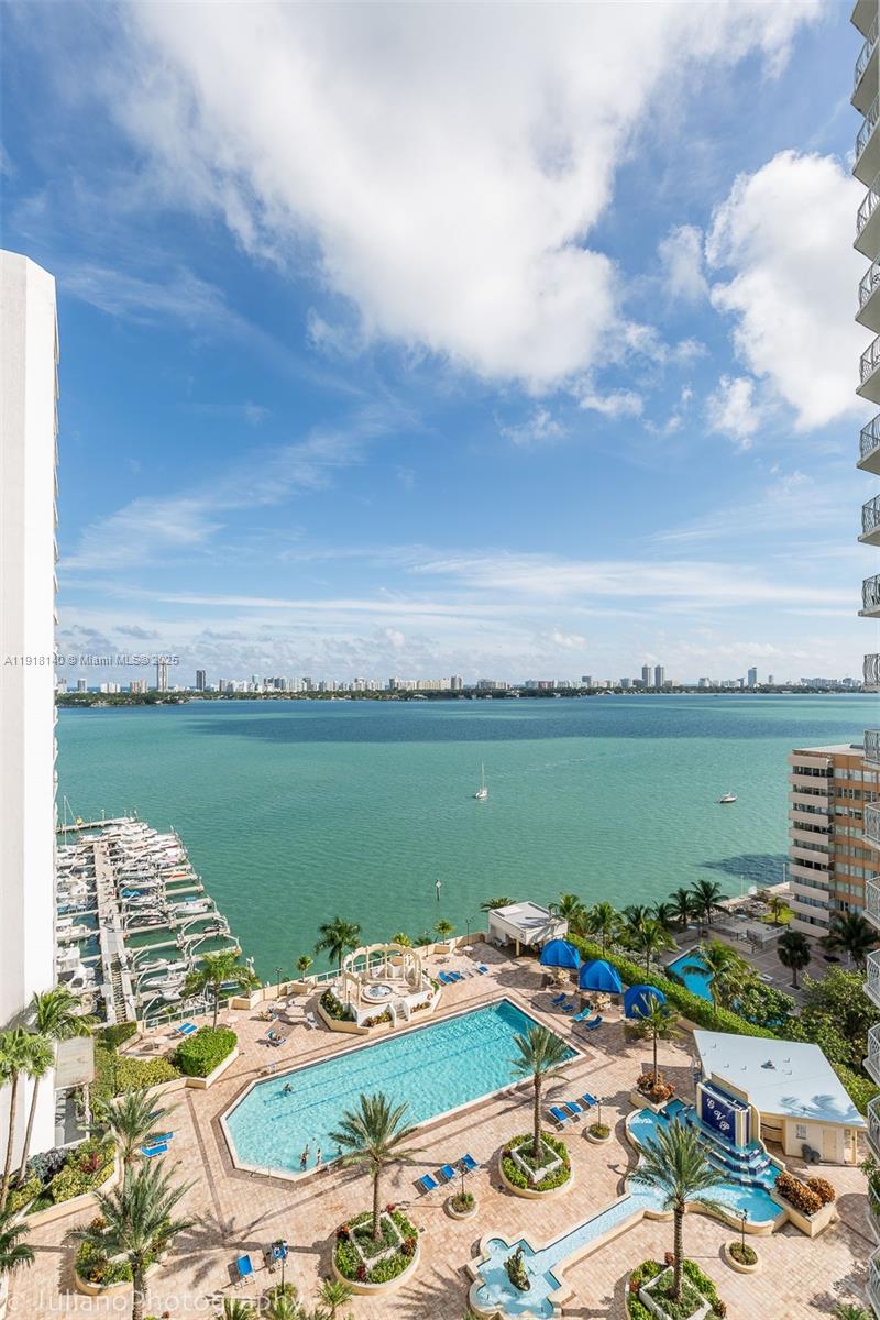7601 East Treasure Drive, Unit PH215 North Bay Village, FL 33141 - Photo 29 of 40 a view of a lake with table and chairs next to a yard