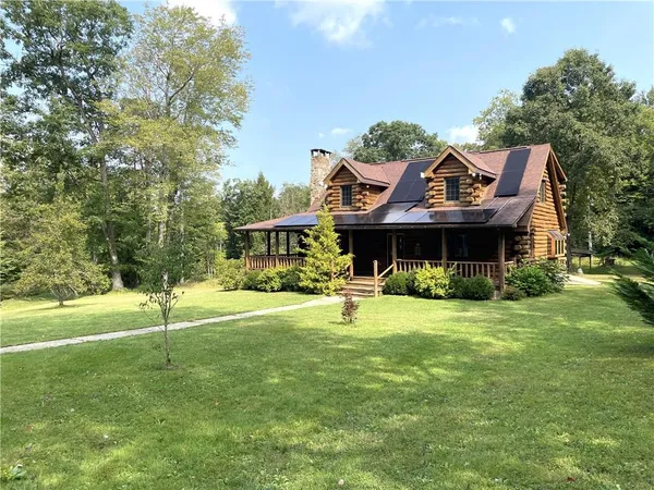 a front view of a house with a garden and trees