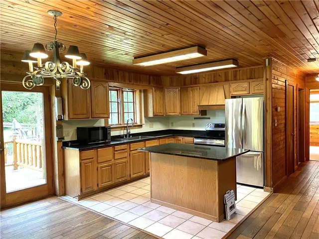 a kitchen with granite countertop a sink appliances cabinets and dining table