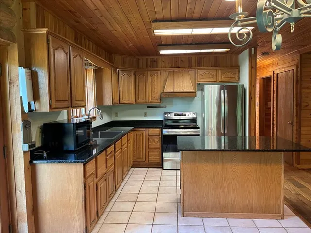 a kitchen with stainless steel appliances granite countertop a refrigerator a sink and a stove