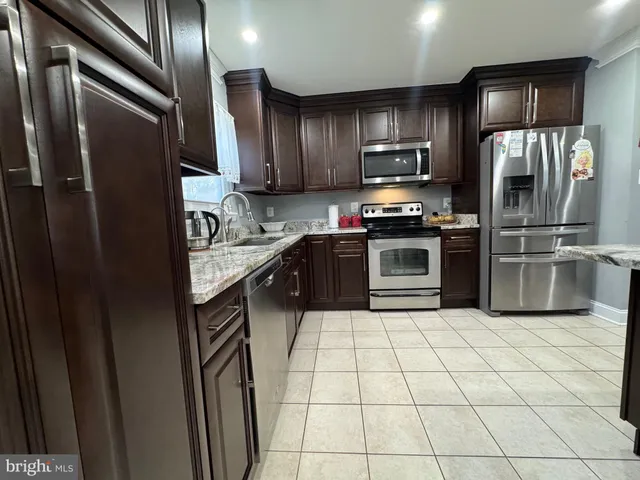 a kitchen with granite countertop a refrigerator and a sink