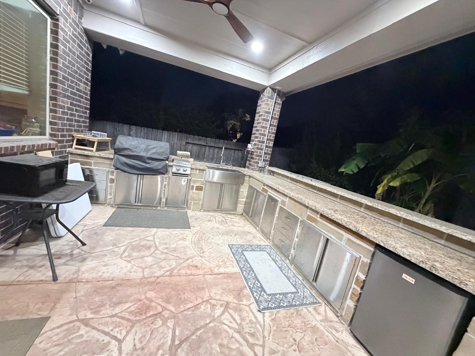 4815 Ashley Hope Drive Katy, TX 77494 - Photo 3 of 26 a outdoor kitchen with a sink and chairs