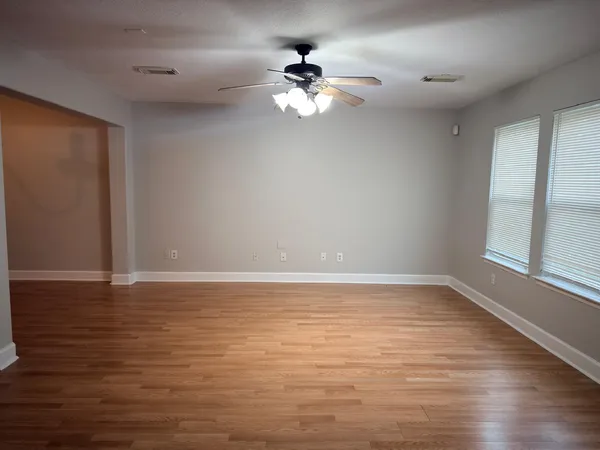 a view of a room with wooden floor and a ceiling fan
