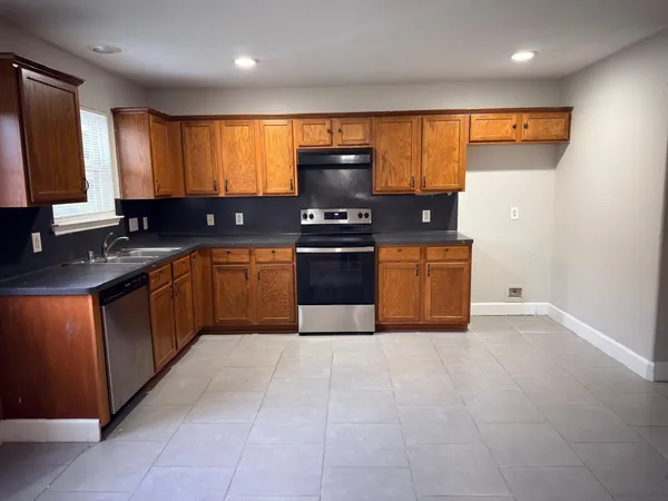 a kitchen with stainless steel appliances granite countertop a stove a sink and a refrigerator