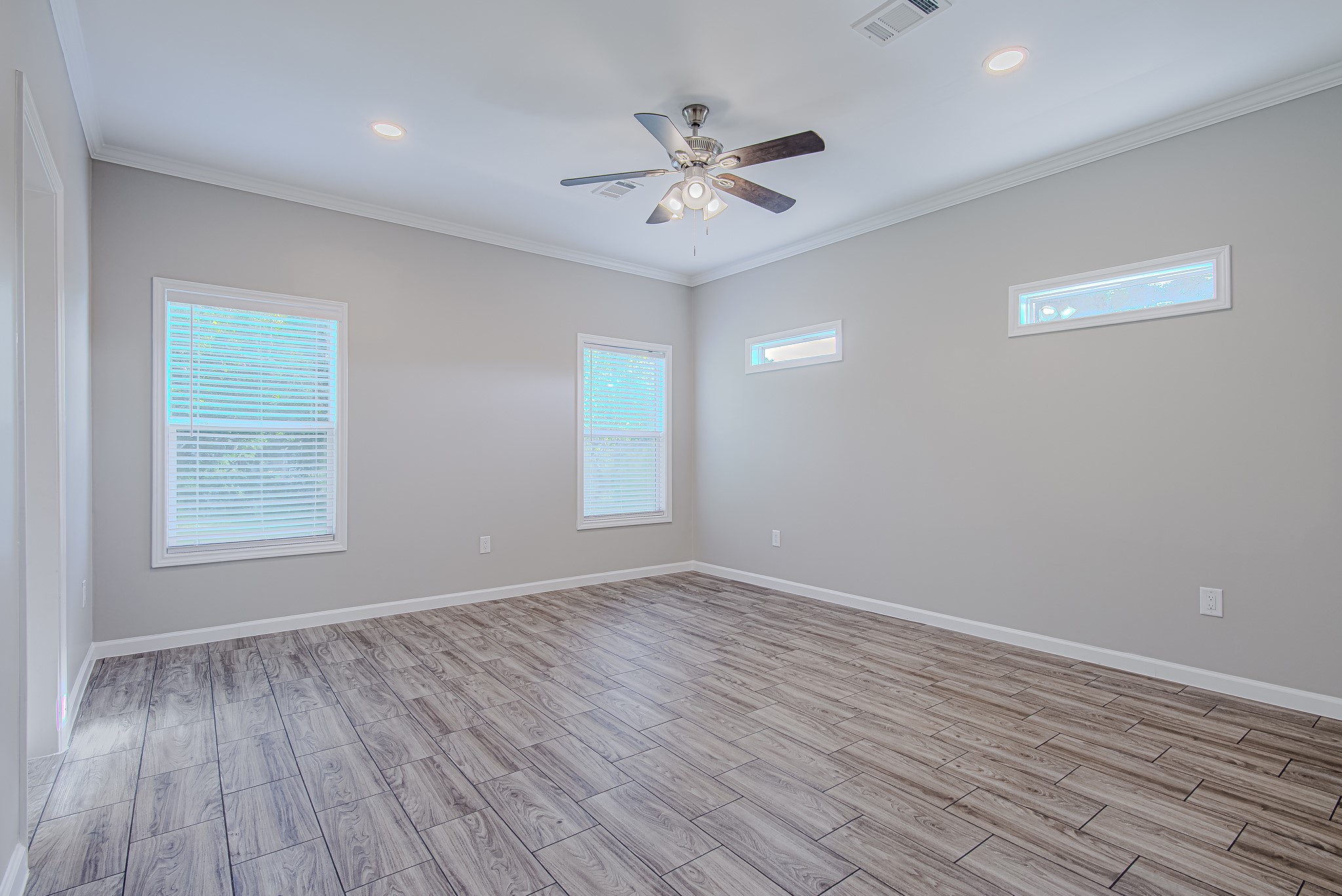 778 Pickering Street Houston, TX 77091 - Photo 13 of 26 Spacious primary bedroom featuring a ceiling fan, wood-style flooring, and multiple windows for natural light