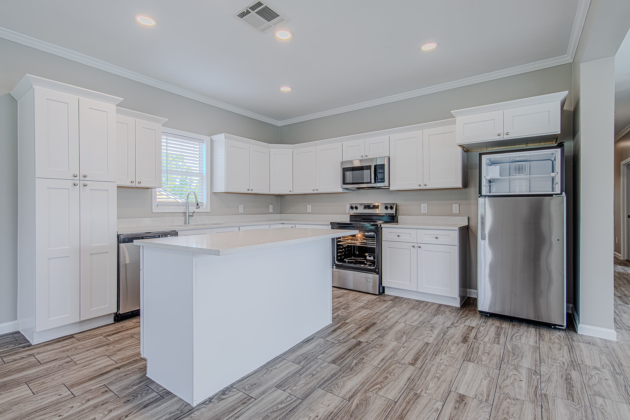 778 Pickering Street Houston, TX 77091 - Photo 5 of 26 Another angle of the kitchen featuring a central island, ample cabinetry, and modern appliances