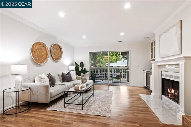 a living room with furniture a fireplace and wooden floor