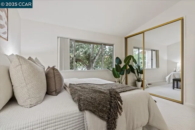a bedroom with a large bed and a potted plant
