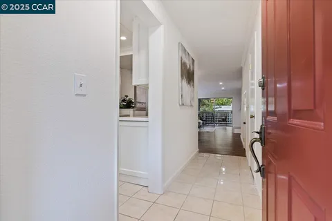 a view of a hallway with wooden floor windows and a bathroom