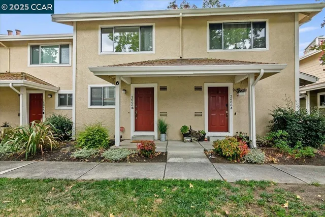 a front view of a house with a yard and potted plants