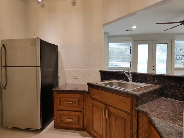 a kitchen with stainless steel appliances granite countertop white cabinets and a stove top oven