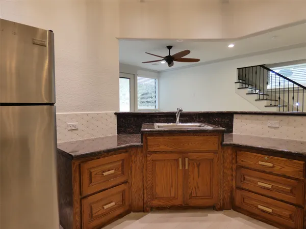 a kitchen with stainless steel appliances granite countertop a refrigerator and a sink