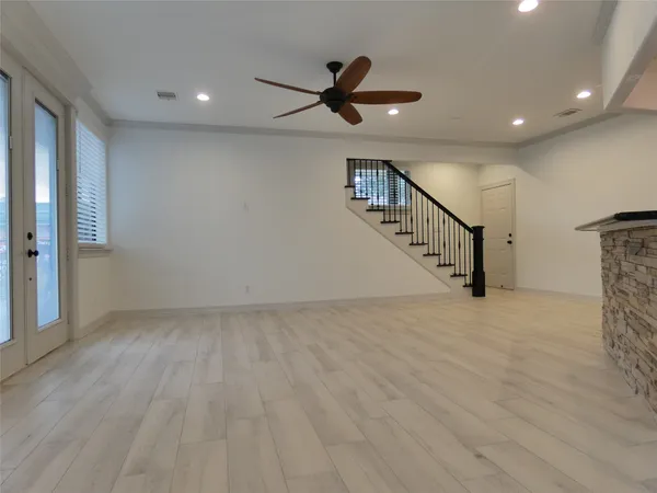 a view of an empty room with a window and wooden floor