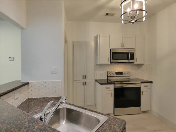 a kitchen with a refrigerator and a sink