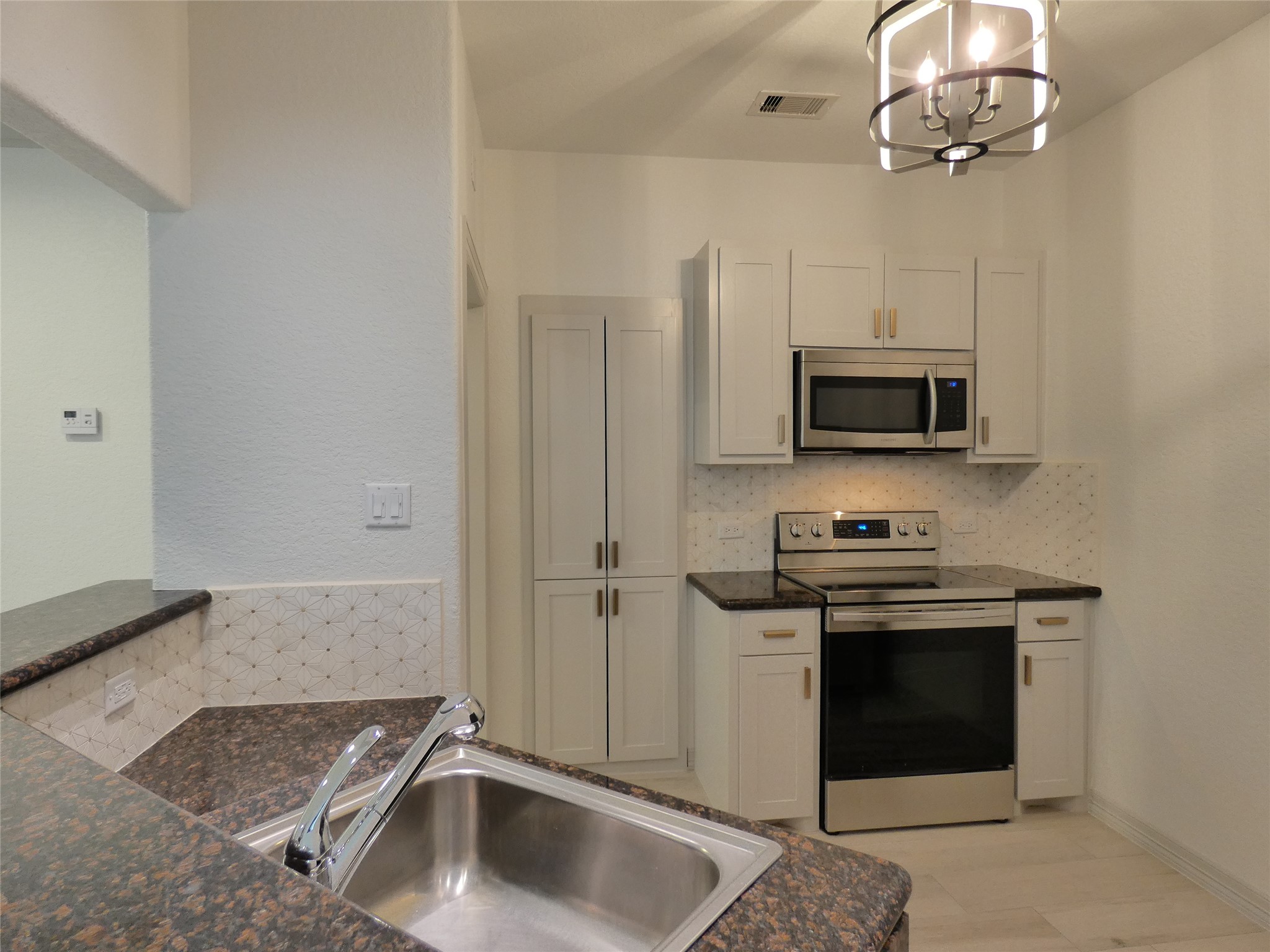 4832 FM 2218 Road, Unit B Rosenberg, TX 77469 - Photo 10 of 33 a kitchen with stainless steel appliances granite countertop a sink a stove and a microwave