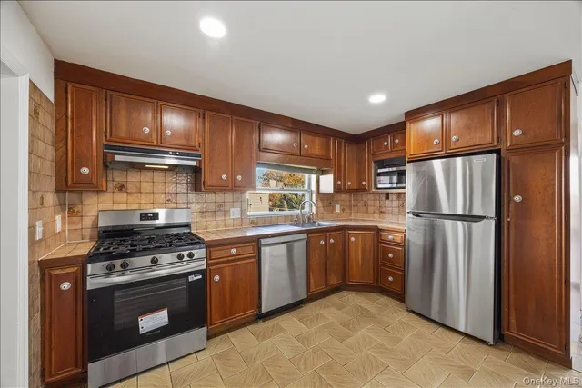 a kitchen with stainless steel appliances granite countertop a refrigerator stove and sink