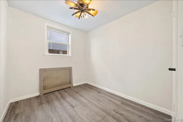 an empty room with a window and wooden floor