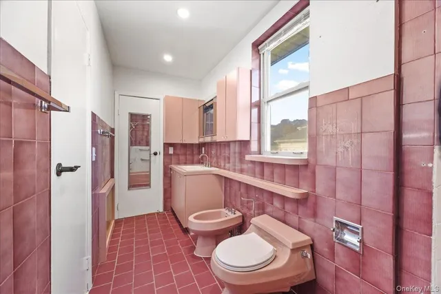a white toilet sitting next to a bathroom sink