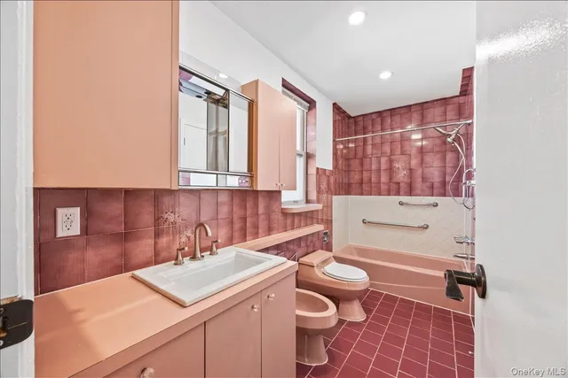 a bathroom with a sink a toilet a mirror and shower