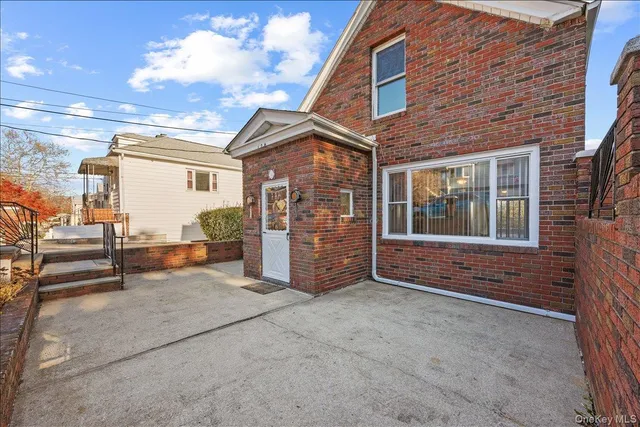 a view of a house with a barbeque and wooden fence