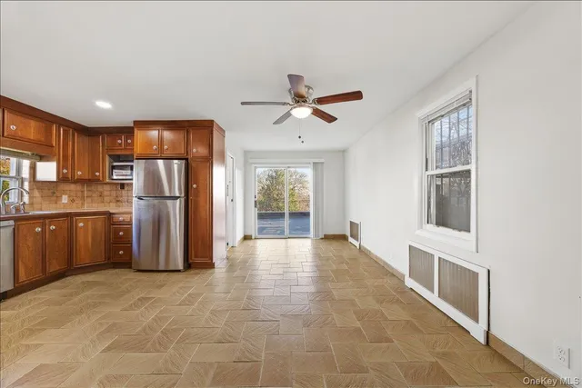 a view of kitchen with stainless steel appliances granite countertop a refrigerator and a stove top oven