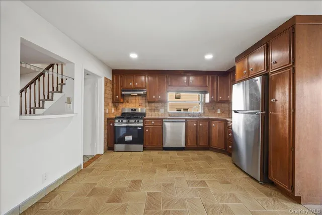 a kitchen with stainless steel appliances granite countertop a refrigerator and a refrigerator