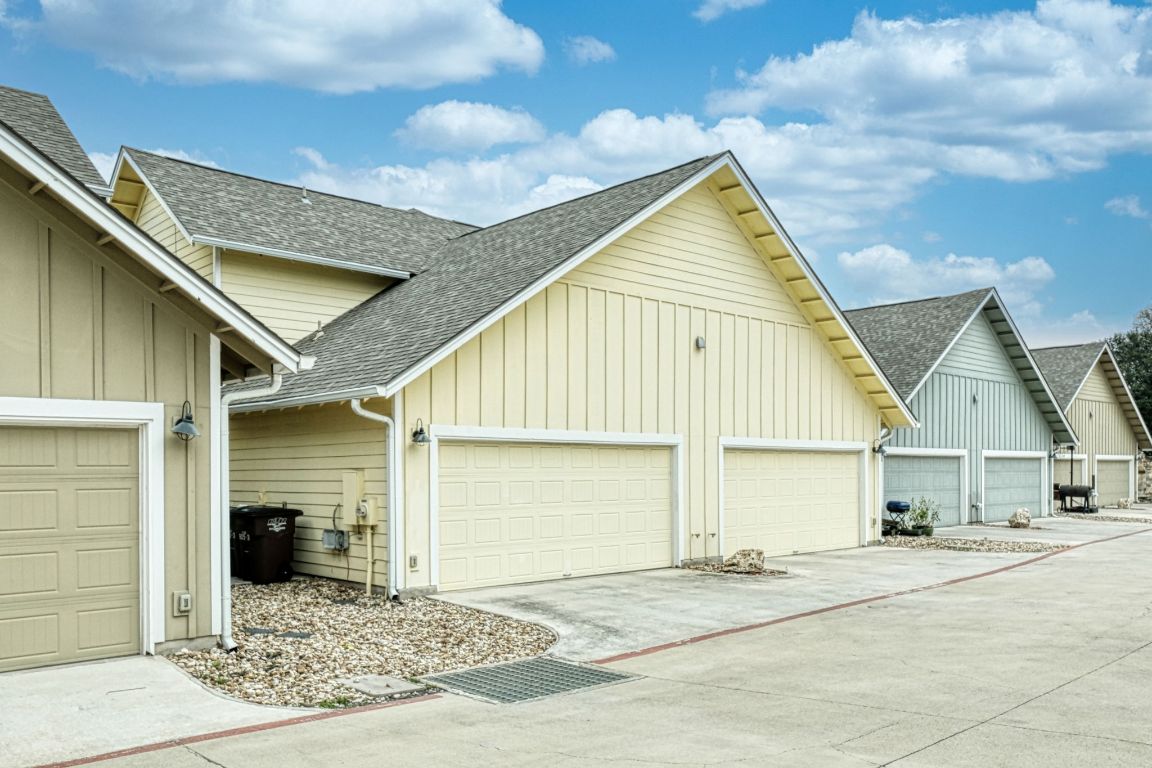 605 Pecan Avenue, Unit 3 Round Rock, TX 78664 - Photo 12 of 15 View of side of property featuring roof with shingles, board and batten siding, concrete driveway, and an attached garage