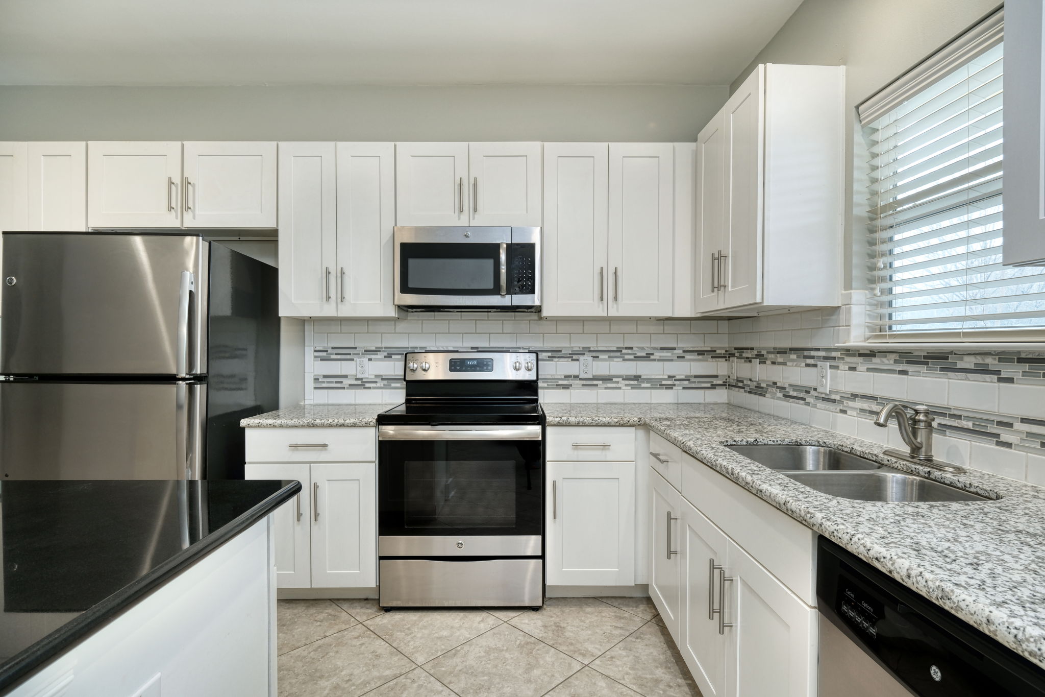 605 Pecan Avenue, Unit 3 Round Rock, TX 78664 - Photo 4 of 15 Kitchen with appliances with stainless steel finishes, backsplash, white cabinetry, and light stone counters