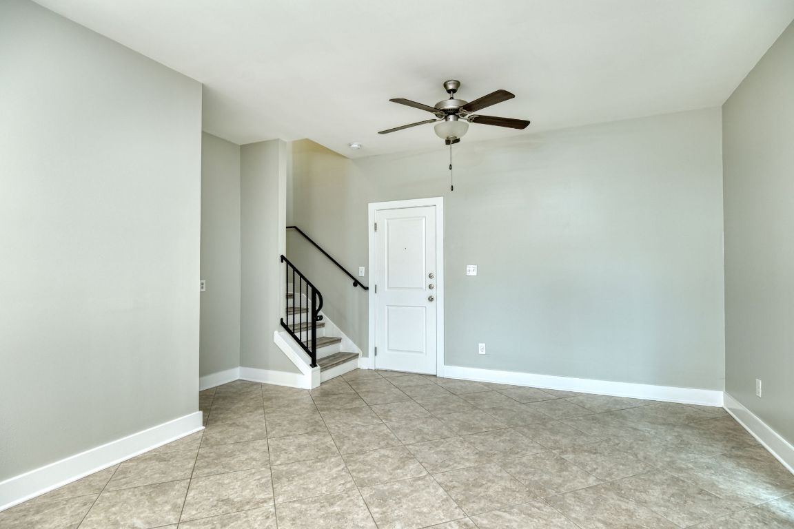 605 Pecan Avenue, Unit 3 Round Rock, TX 78664 - Photo 5 of 15 Empty room with ceiling fan, stairs, and light tile patterned floors