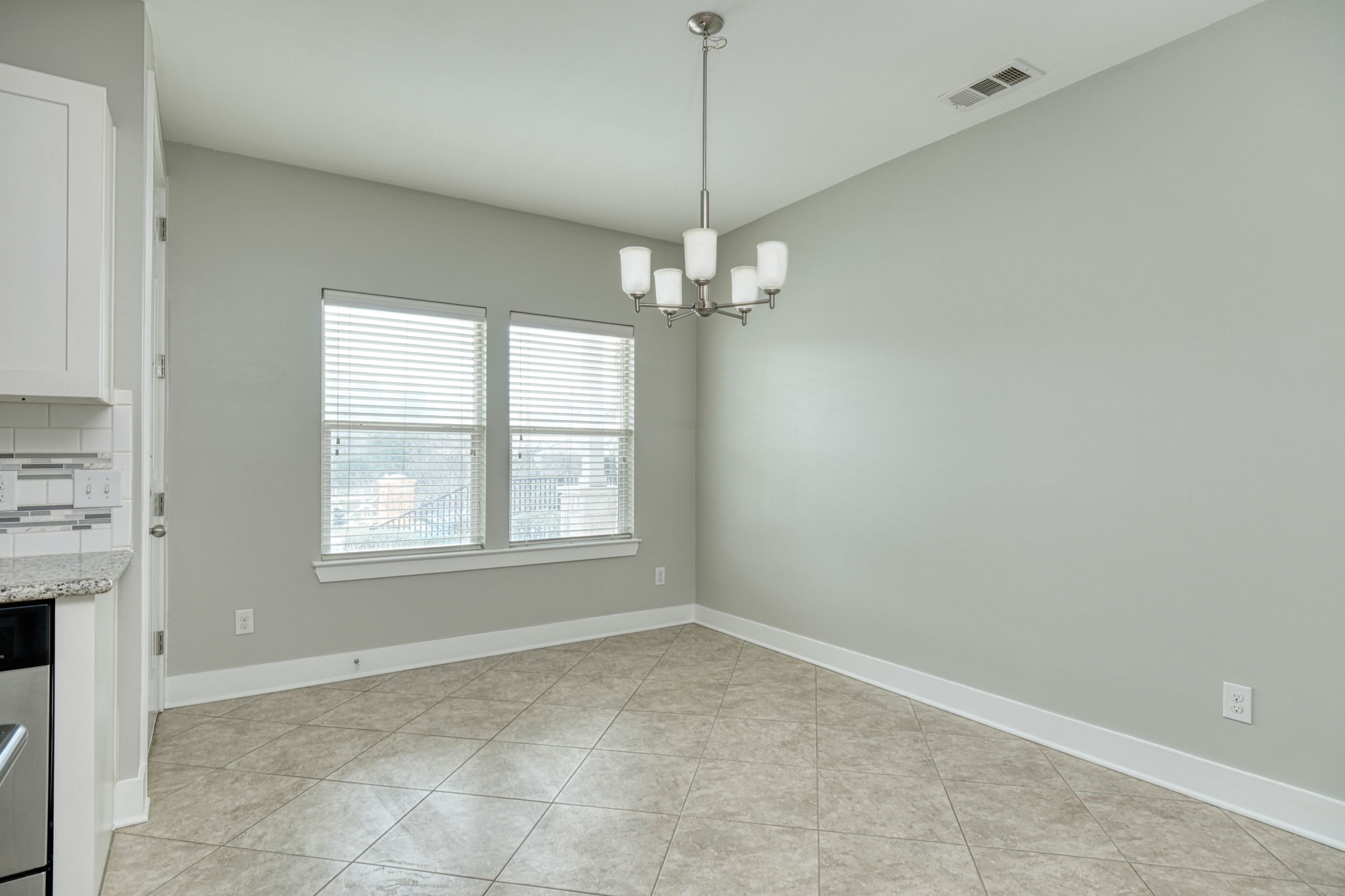 605 Pecan Avenue, Unit 3 Round Rock, TX 78664 - Photo 6 of 15 Unfurnished dining area featuring light tile patterned flooring and a chandelier