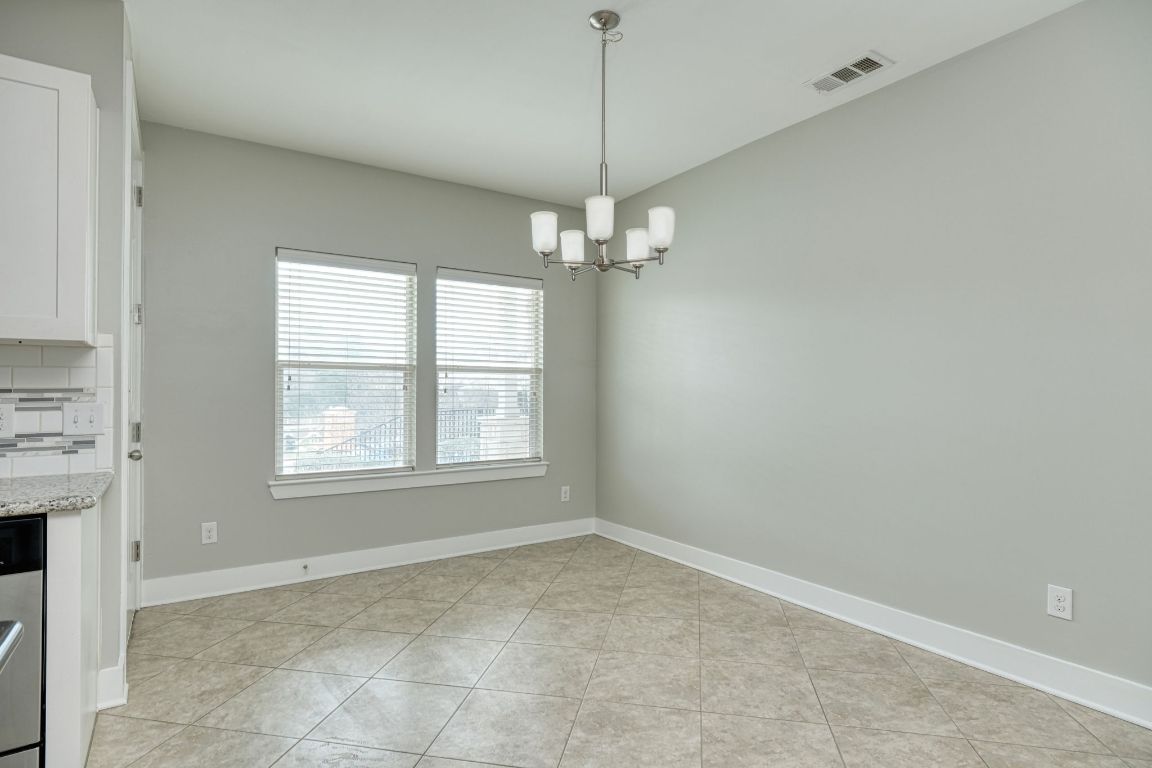 605 Pecan Avenue, Unit 3 Round Rock, TX 78664 - Photo 6 of 15 Unfurnished dining area featuring light tile patterned flooring and a chandelier