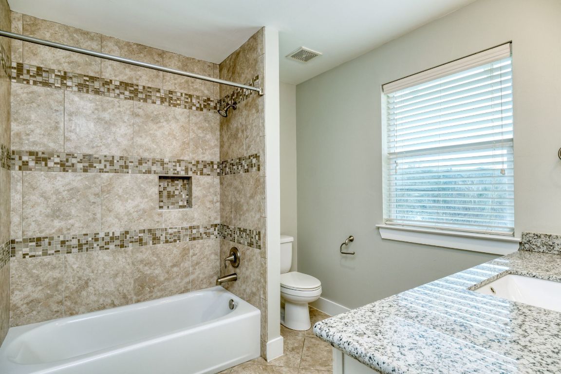 605 Pecan Avenue, Unit 3 Round Rock, TX 78664 - Photo 9 of 15 Full bathroom featuring vanity, bathtub / shower combination, and light tile patterned floors