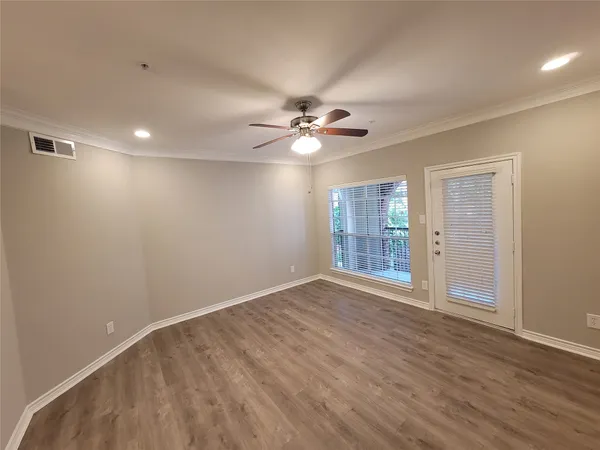a view of an empty room with a ceiling fan and window