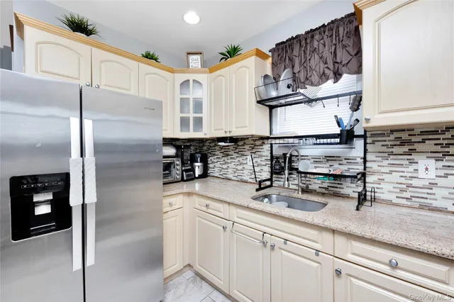 a kitchen with stainless steel appliances granite countertop a sink a refrigerator and a granite counter tops