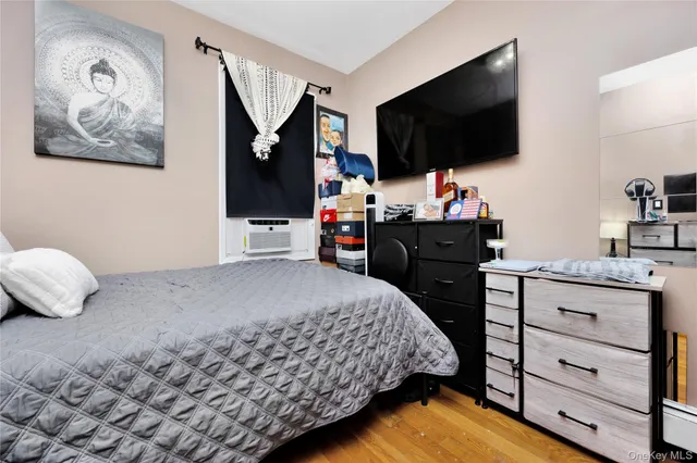 a bedroom with a bed and flat tv screen on the dresser
