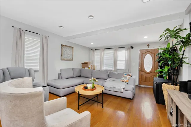 a living room with furniture a large window and a potted plant