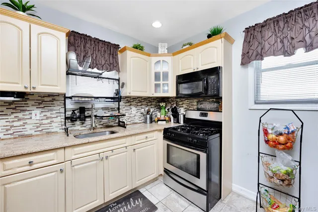 a kitchen with stainless steel appliances granite countertop a stove a sink and a microwave