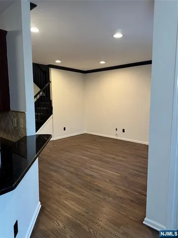 an empty room with wooden floor and entryway