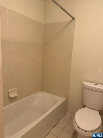 a white toilet sitting next to a bath tub