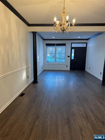 a view of a room with wooden floor and chandelier