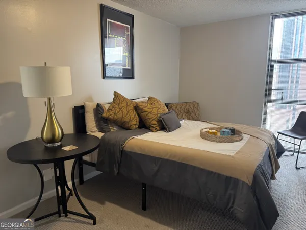 a bedroom with a bed a table and chair