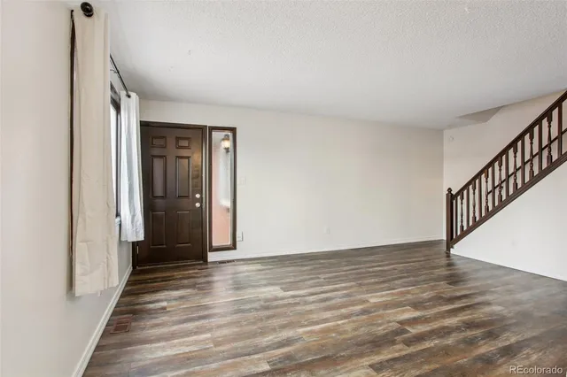 a view of a hallway with wooden floor and chandelier