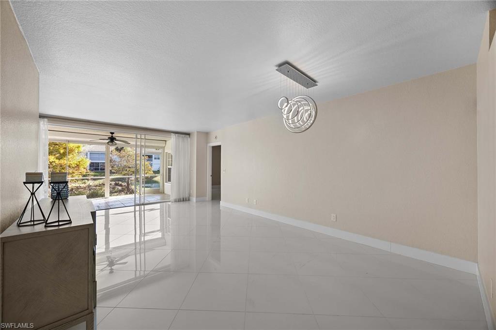 6834 Lantana Bridge Road, Unit 101 Naples, FL 34109 - Photo 16 of 50 a view of a kitchen with fridge and wooden floor