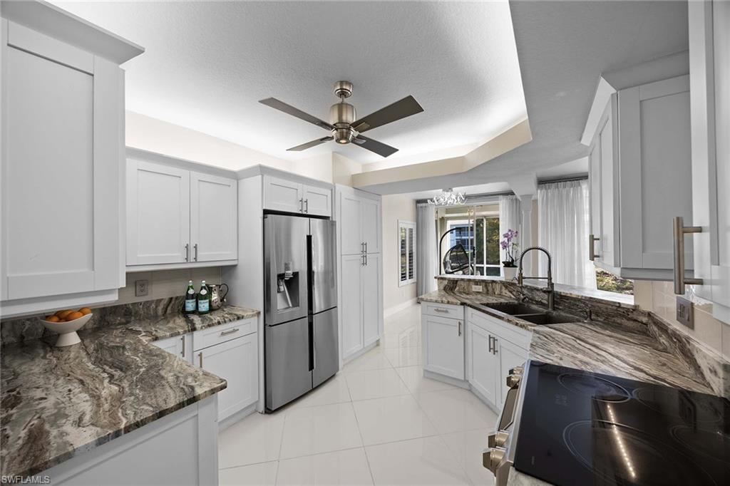 6834 Lantana Bridge Road, Unit 101 Naples, FL 34109 - Photo 21 of 50 a kitchen with stainless steel appliances granite countertop a sink stove and refrigerator