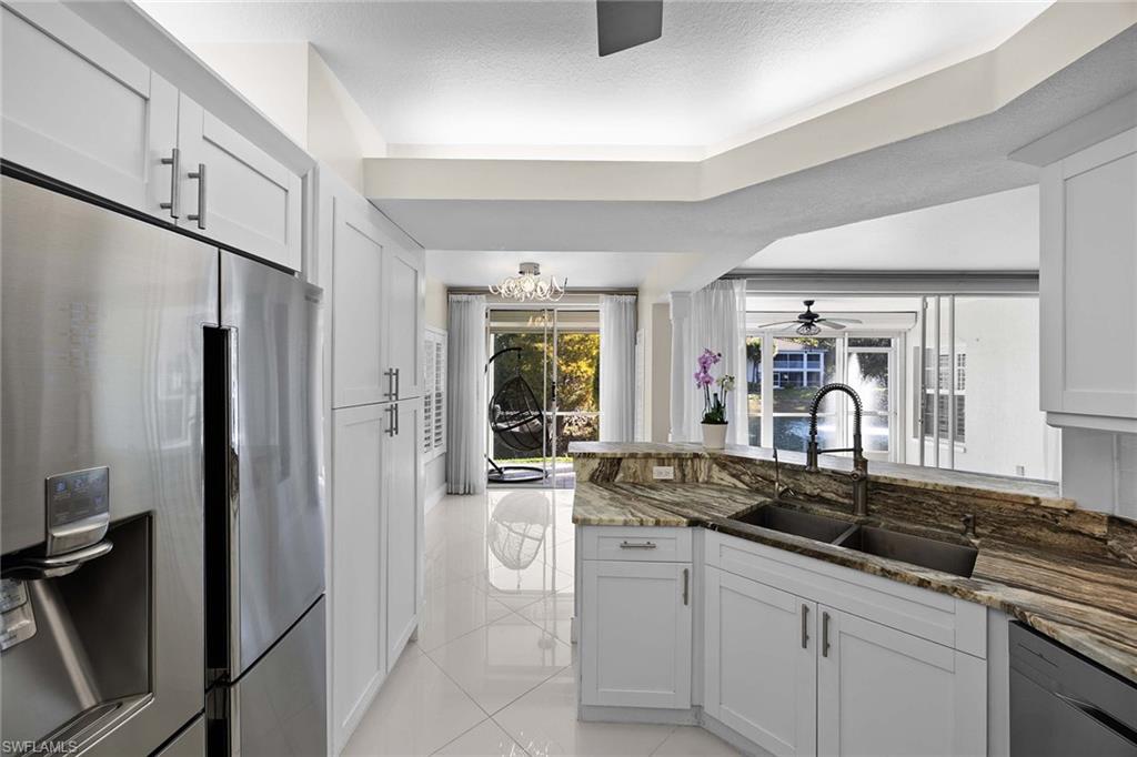 6834 Lantana Bridge Road, Unit 101 Naples, FL 34109 - Photo 23 of 50 a kitchen with stainless steel appliances granite countertop a sink and a refrigerator