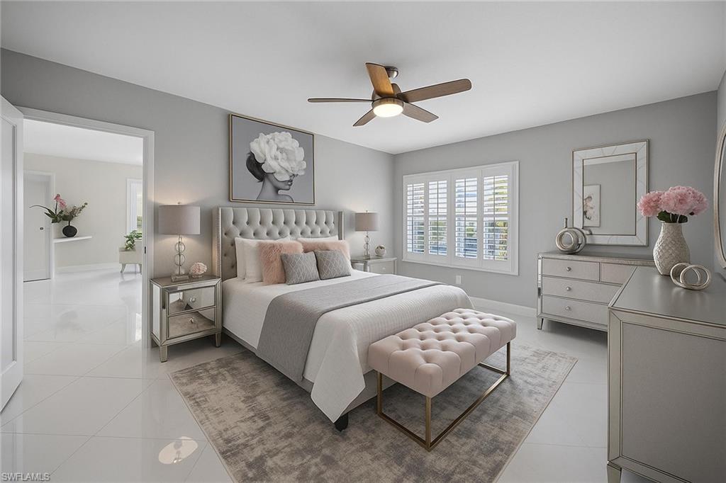 6834 Lantana Bridge Road, Unit 101 Naples, FL 34109 - Photo 4 of 50 a bedroom with a bed and a chandelier