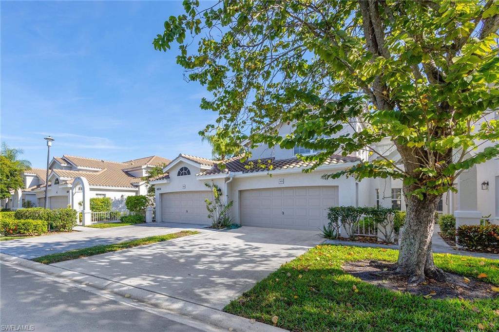6834 Lantana Bridge Road, Unit 101 Naples, FL 34109 - Photo 47 of 50 a front view of a house with a yard and a garage