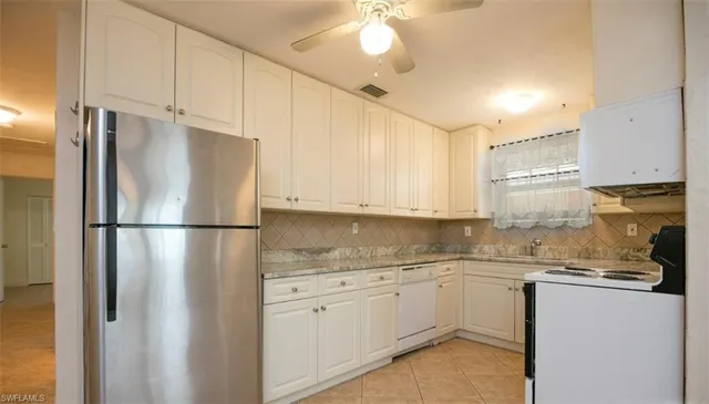 a kitchen with a refrigerator a sink and cabinets