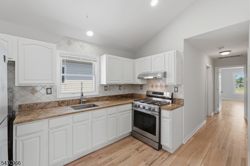 130 3rd Street, Unit 2 Passaic, NJ 07055 - Photo 2 of 12 a kitchen with stainless steel appliances granite countertop a sink stove and cabinets