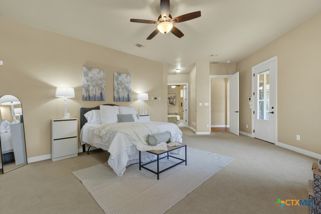 7607 Sky Loop Garden Ridge, TX 78266 - Photo 4 of 43 a spacious bedroom with a bed and a chandelier